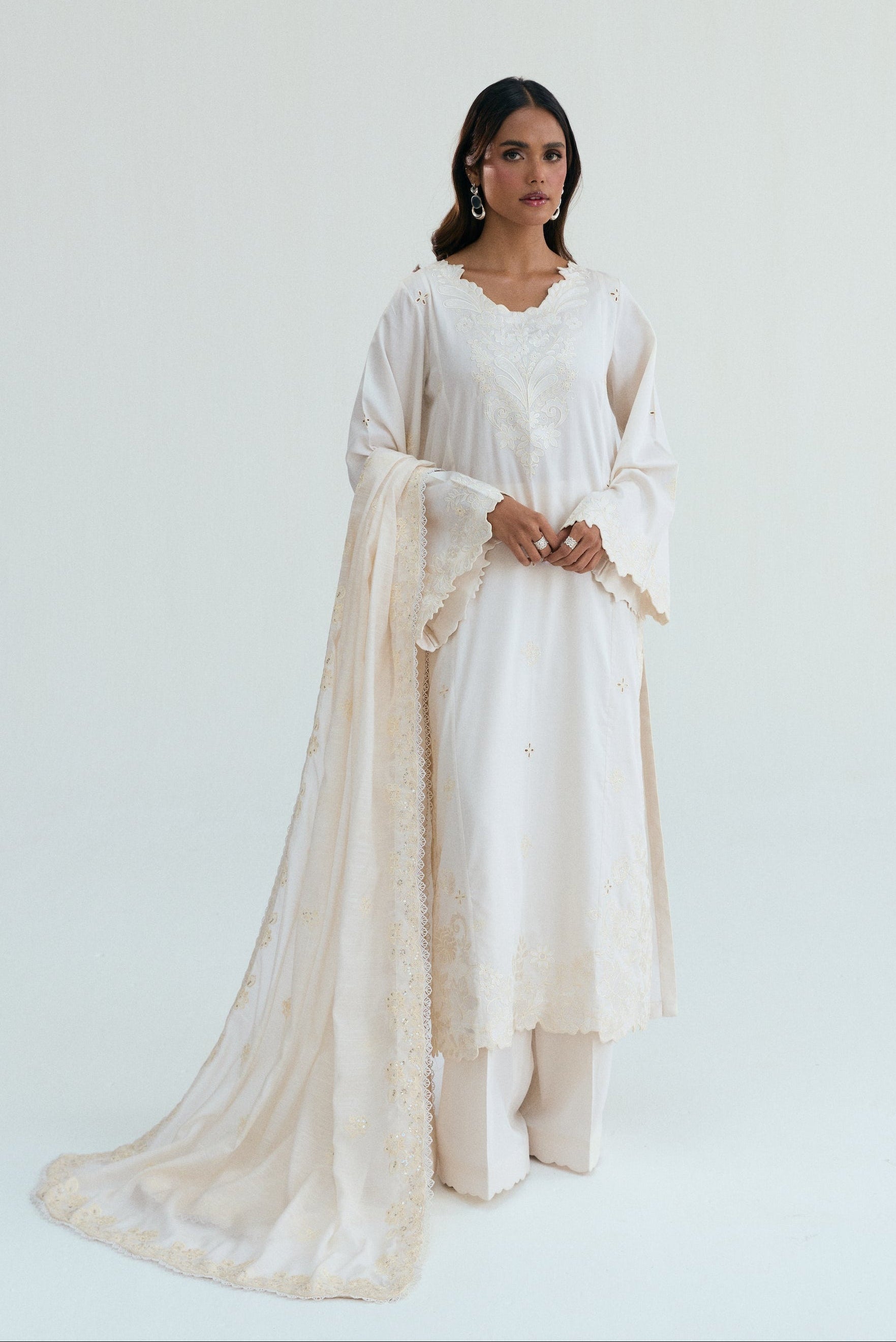  Ivory embroidered outfit with scalloped detailing, long izaar trousers,and sequin dupatta. Ideal for Eid, iftar parties and formal occasions.