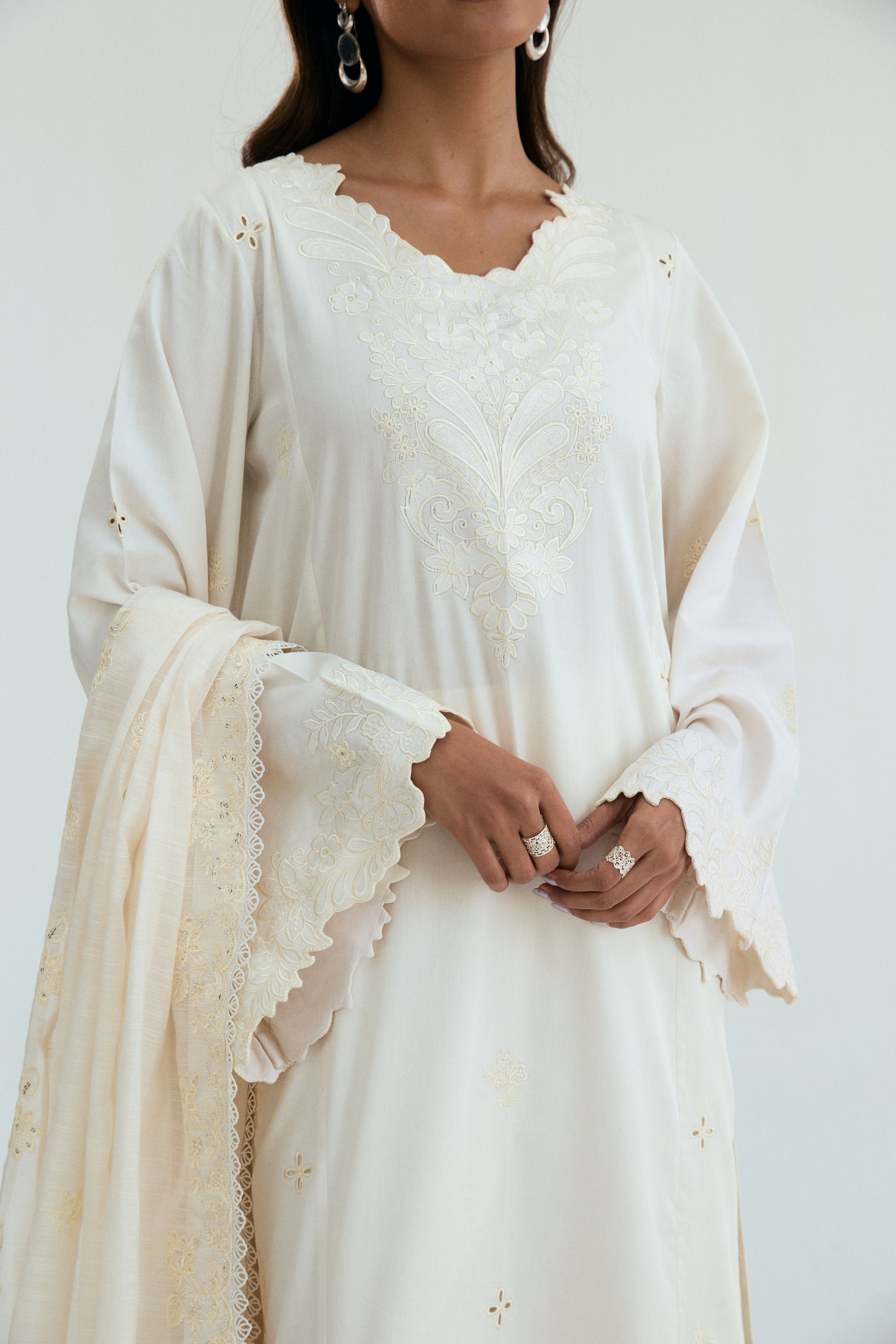  Ivory embroidered outfit with scalloped detailing, long izaar trousers,and sequin dupatta. Ideal for Eid, iftar parties and formal occasions.