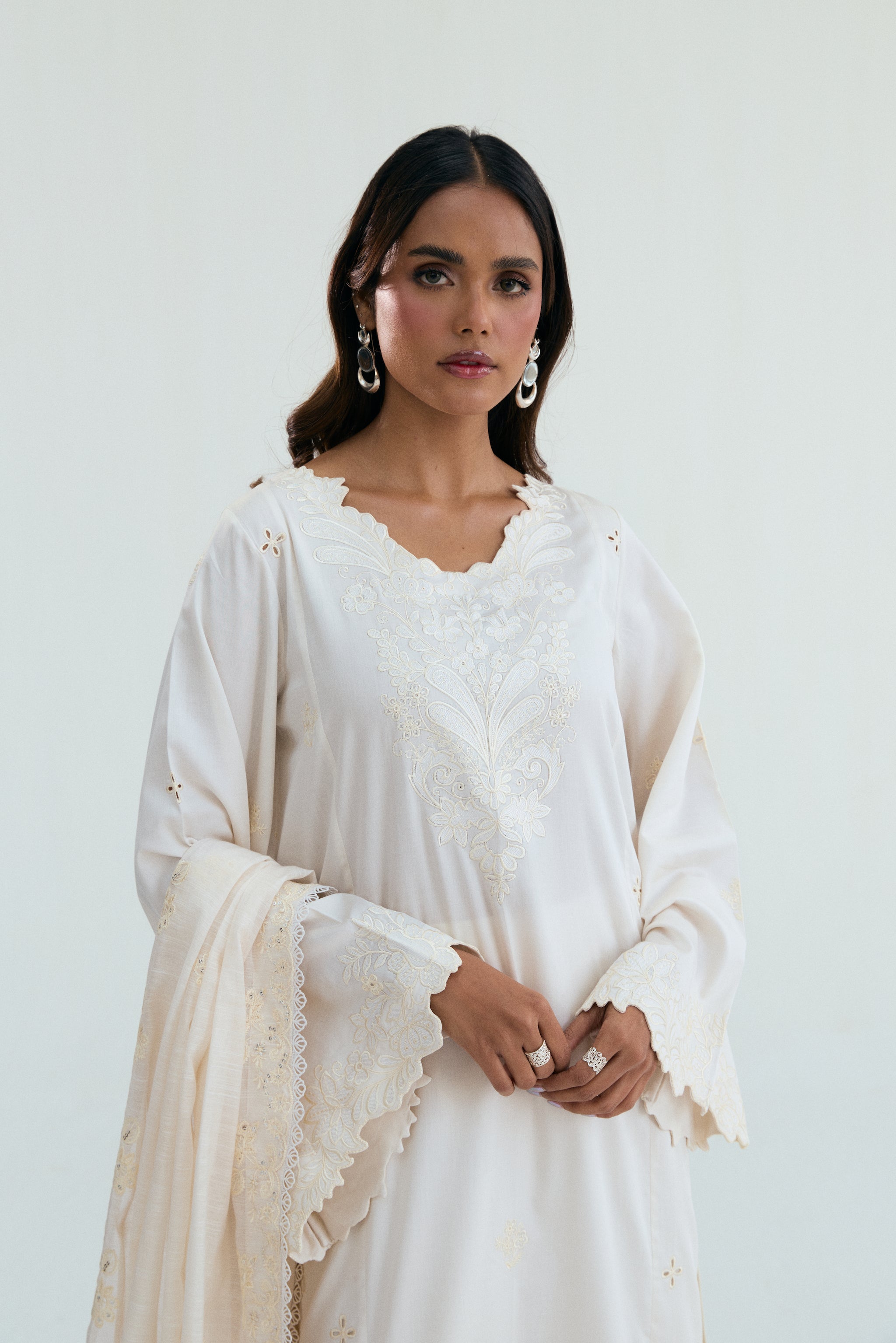  Ivory embroidered outfit with scalloped detailing, long izaar trousers,and sequin dupatta. Ideal for Eid, iftar parties and formal occasions.