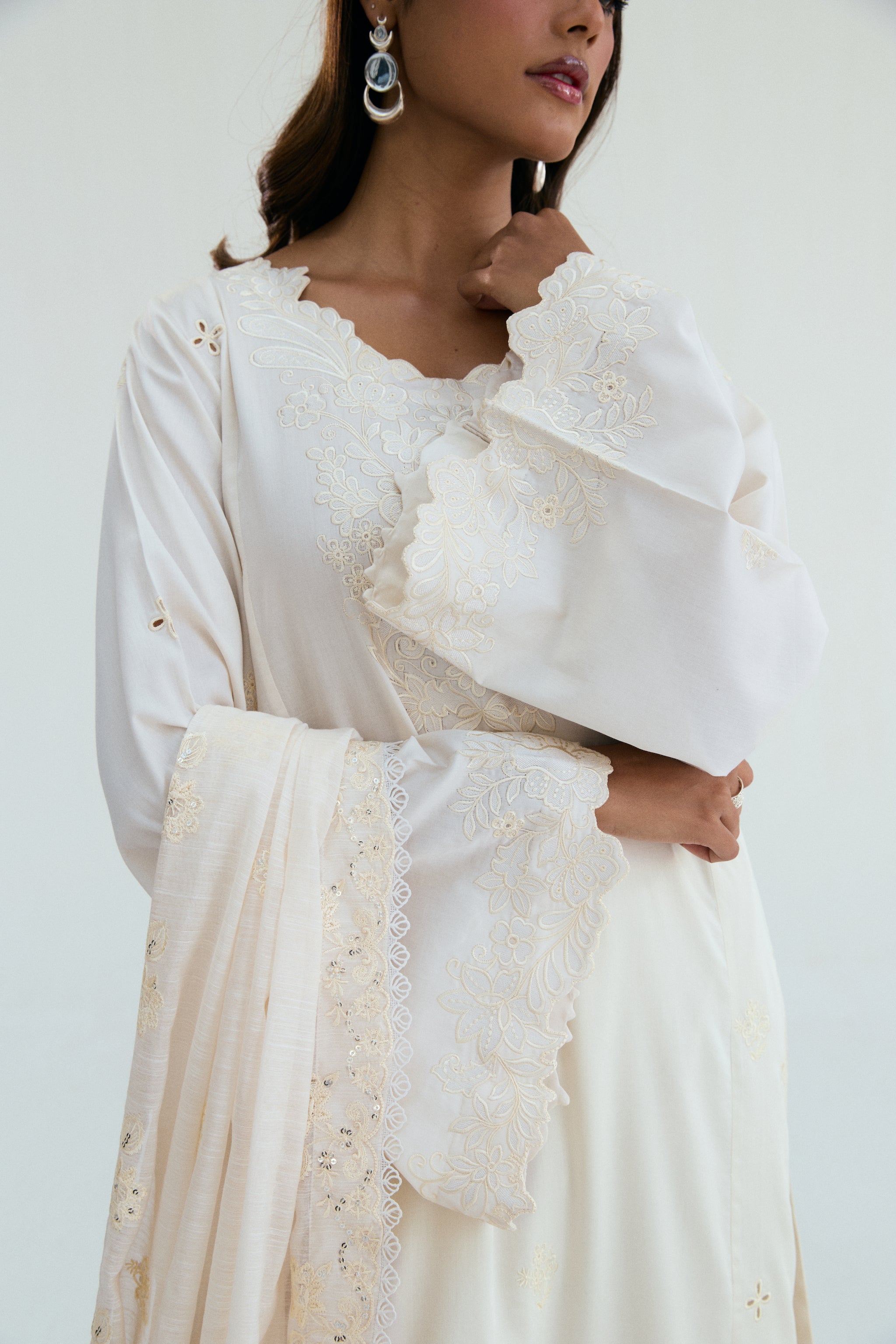  Ivory embroidered outfit with scalloped detailing, long izaar trousers,and sequin dupatta. Ideal for Eid, iftar parties and formal occasions.