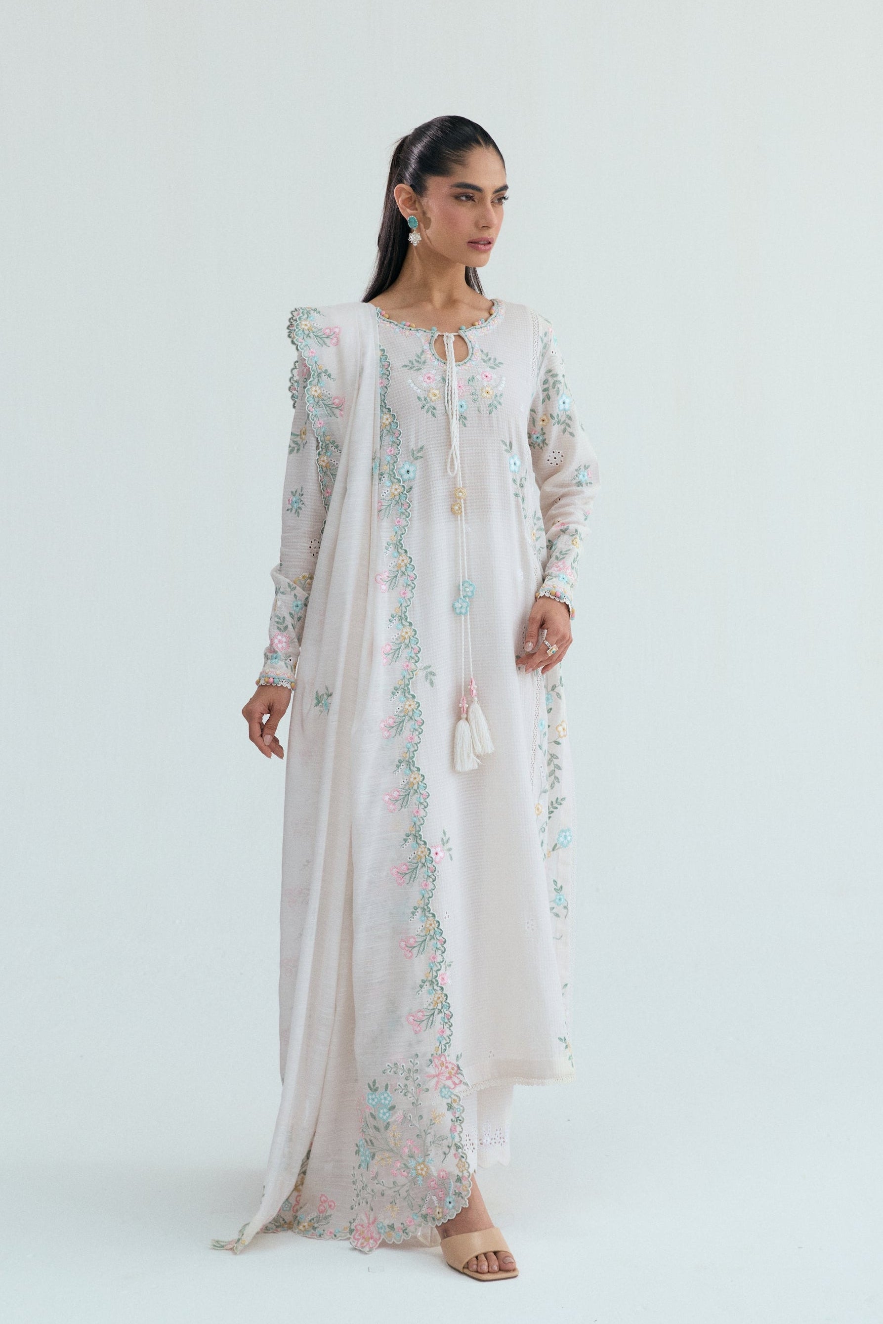 Off-white Pakistani casual wear outfit with floral embroidery, embroidered izaar trousers and scalloped dupatta. Perfect for Eid and special occasions.