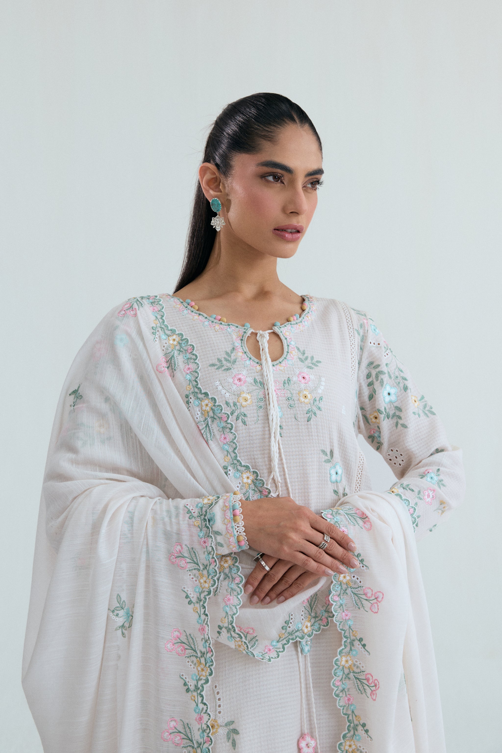 Off-white Pakistani casual wear outfit with floral embroidery, embroidered izaar trousers and scalloped dupatta. Perfect for Eid and special occasions.