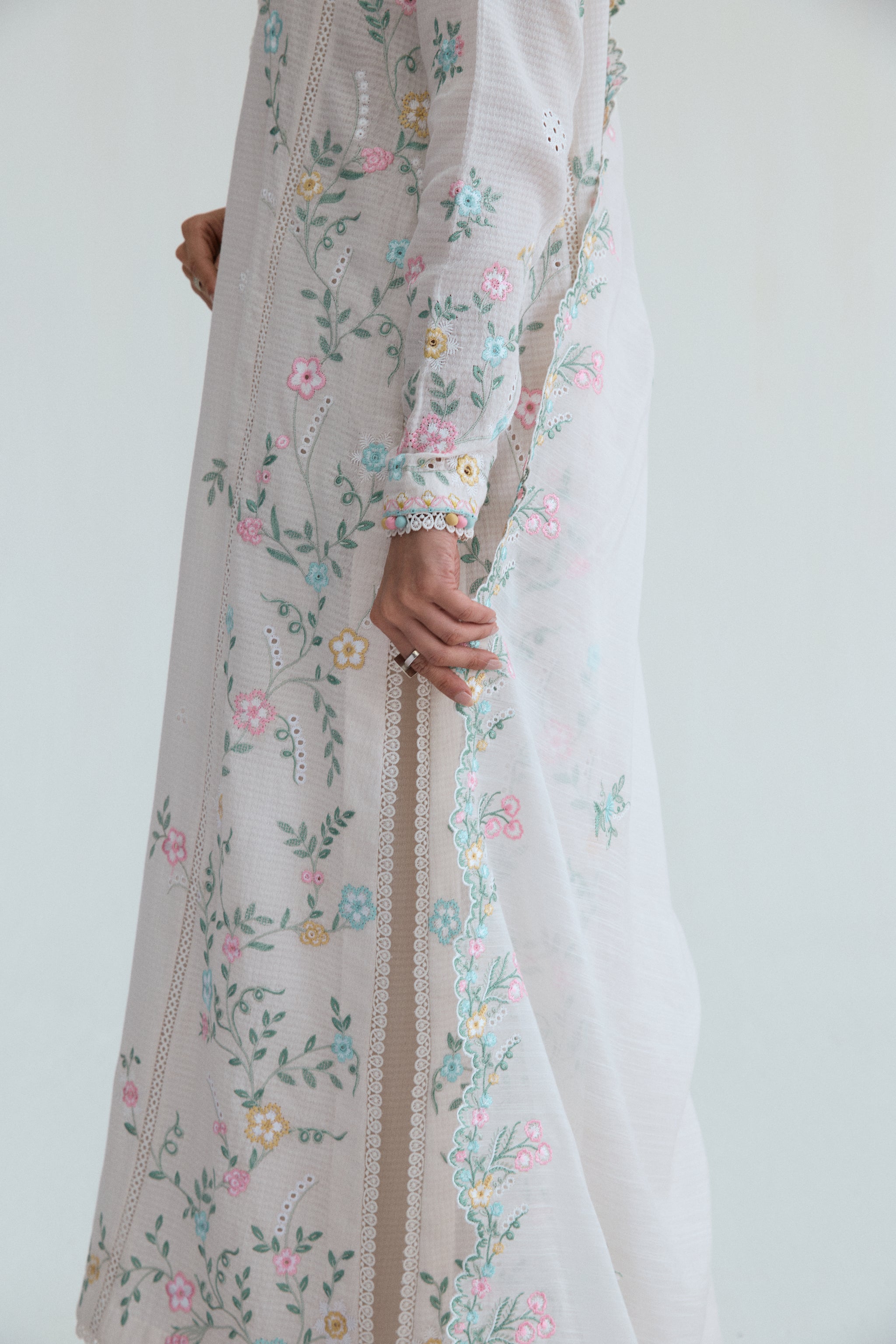 Off-white Pakistani casual wear outfit with floral embroidery, embroidered izaar trousers and scalloped dupatta. Perfect for Eid and special occasions.