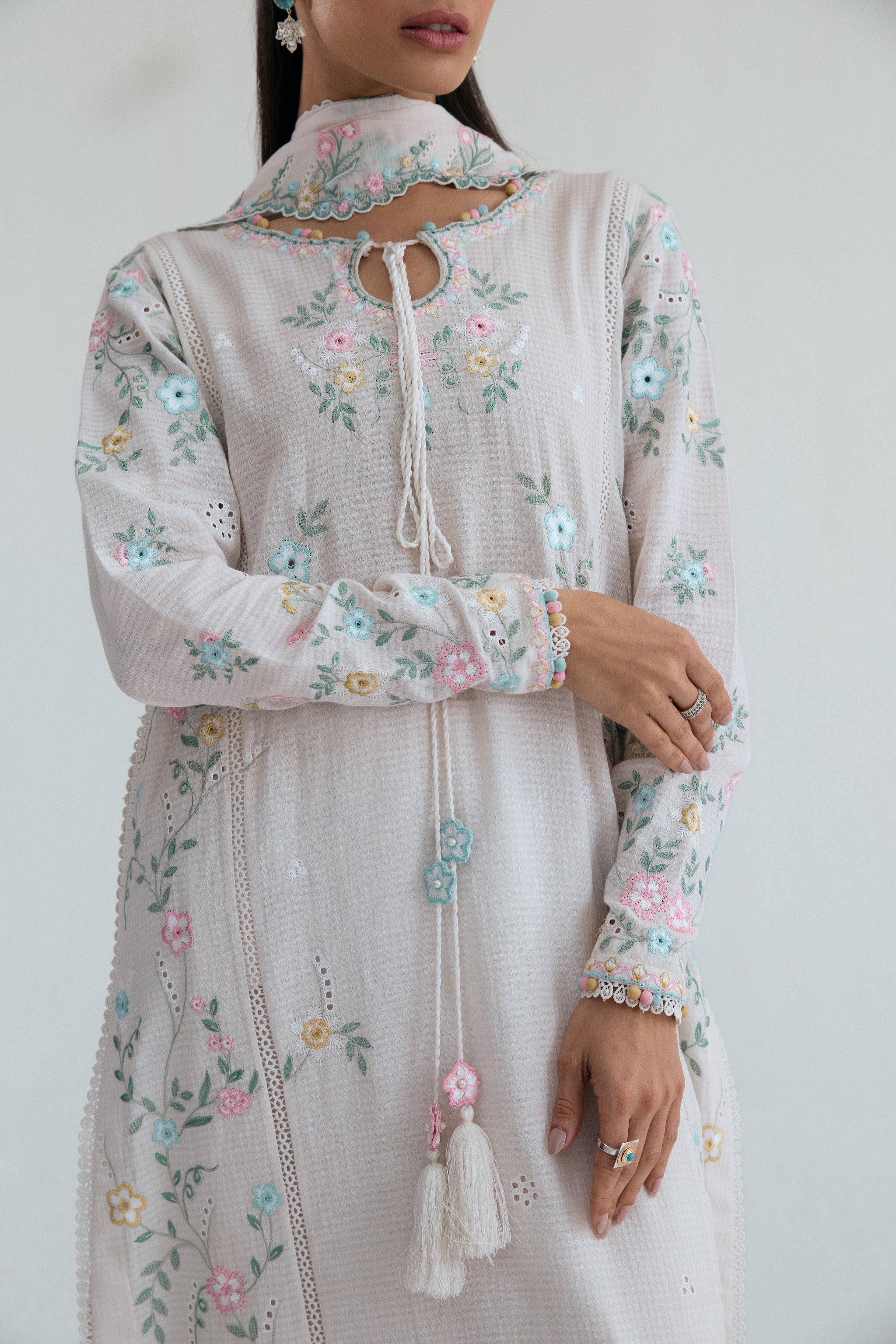 Off-white Pakistani casual wear outfit with floral embroidery, embroidered izaar trousers and scalloped dupatta. Perfect for Eid and special occasions.