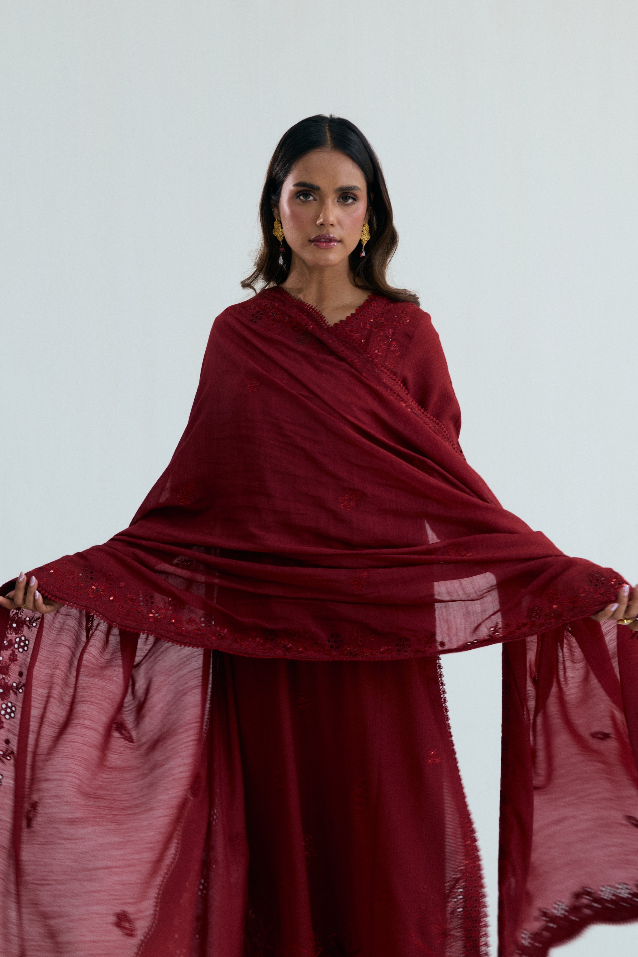 Deep red embroidered Pakistani outfit in dobby cotton with scalloped izaar trousers and slub silk dupatta. Ideal for Eid and festive occasions.