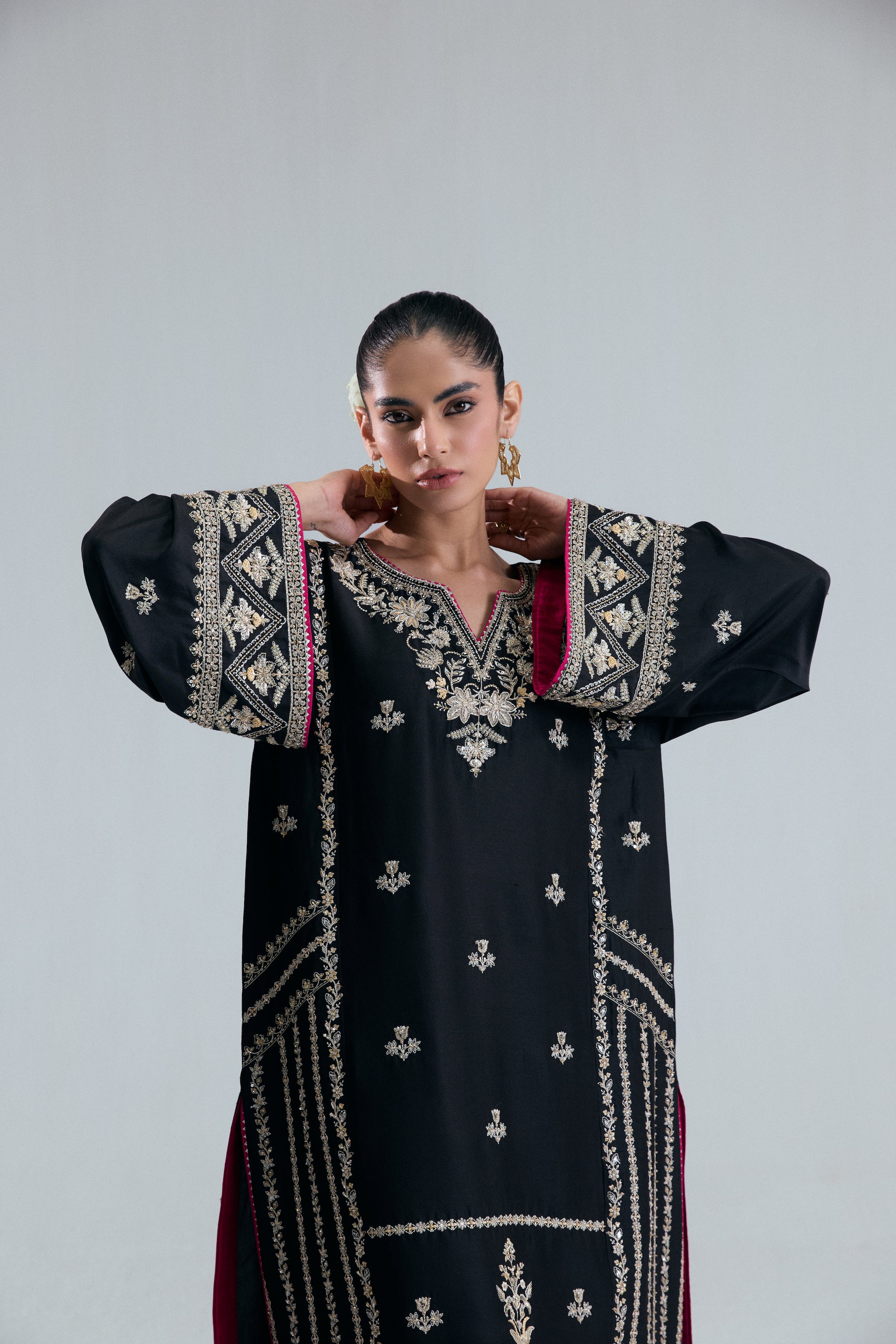 Pakistani formal wear short Phiran in black raw silk with delicate floral threadwork, beads, and metallic accents.