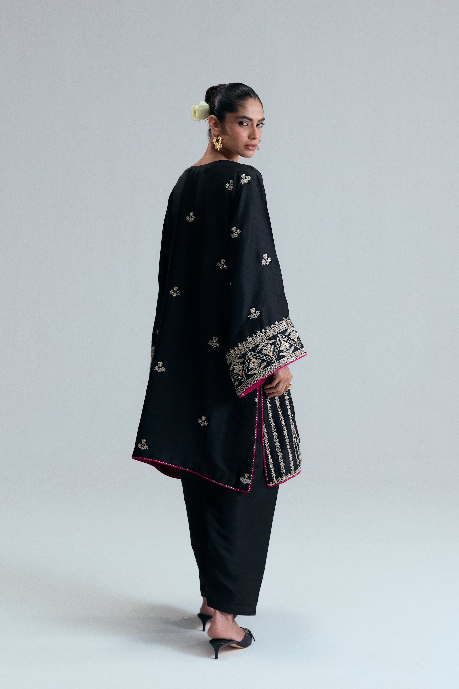 Pakistani formal wear short Phiran in black raw silk with delicate floral threadwork, beads, and metallic accents.