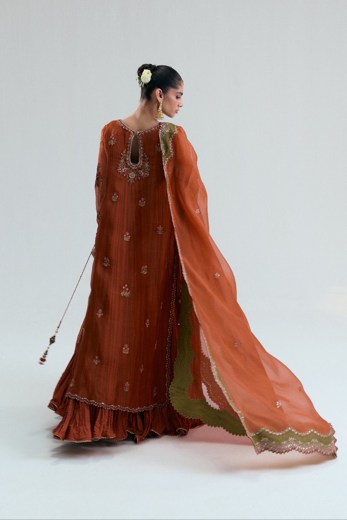 Back view of the burnt orange kameez with the organza dupatta flowing to one side