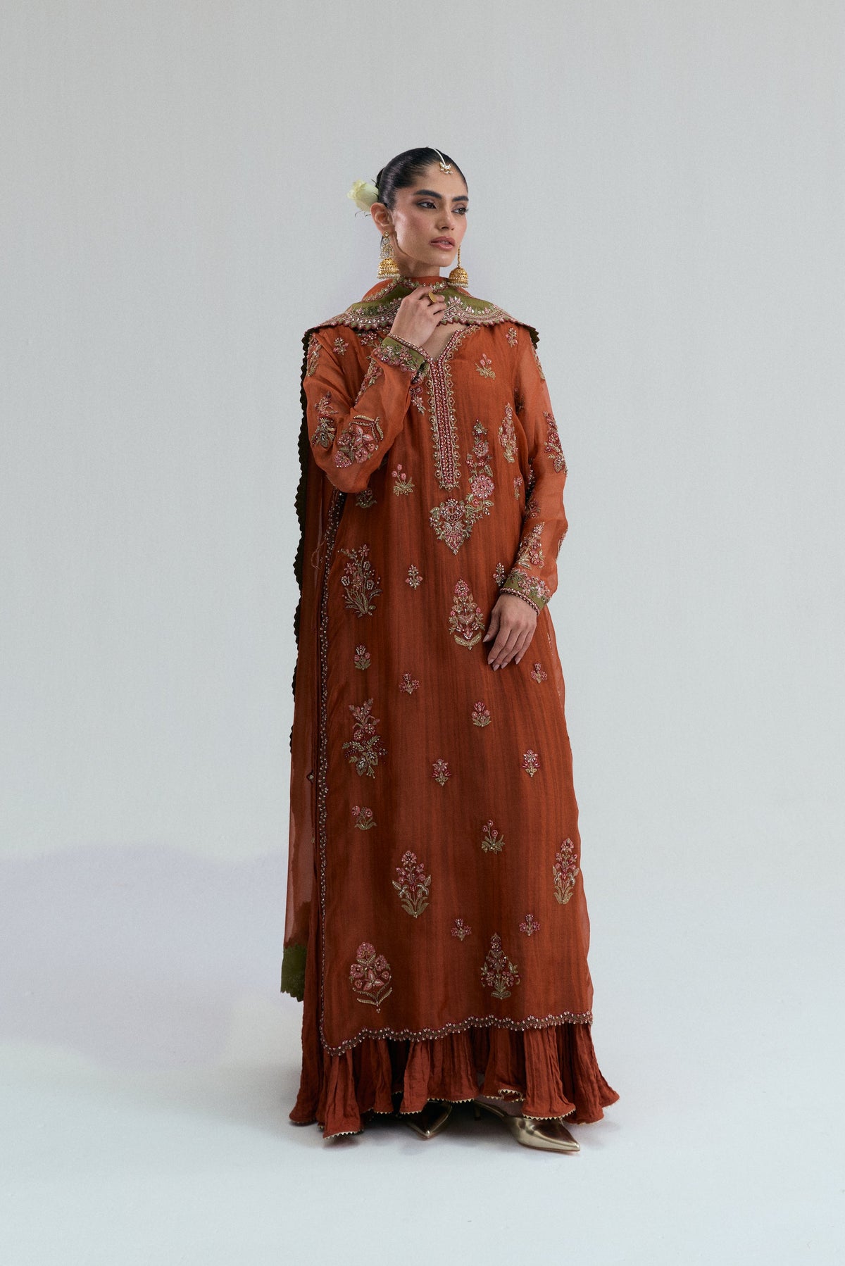 Burnt orange Pakistani suit with multicolored floral embroidery and a scalloped olive-green Dupatta.