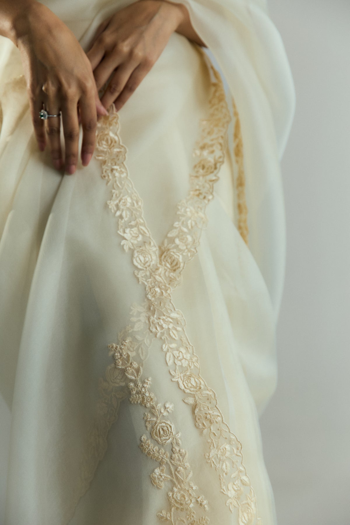 Close-up of the Ghara-style floral embroidery where the edges of the organza saree cross each other at the waist.