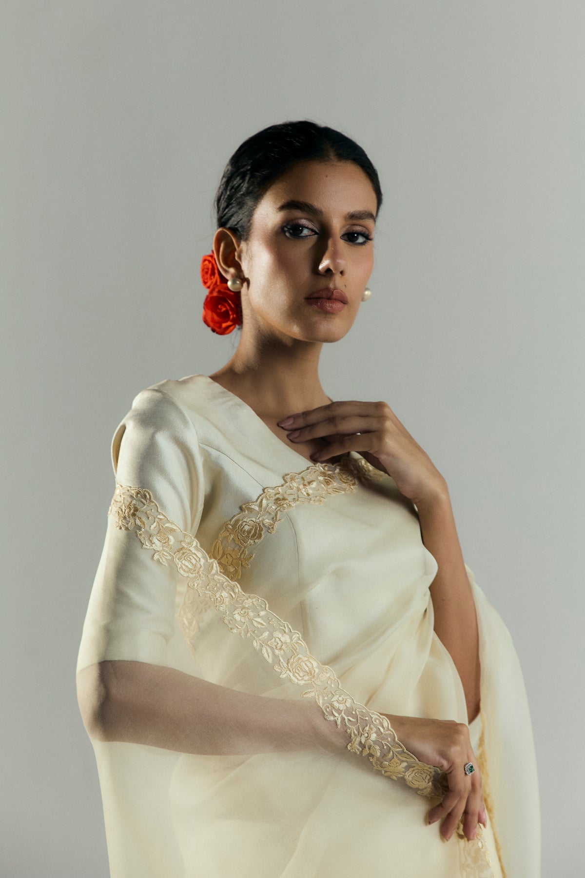 Close-up of the gold floral embroidery trim along the silk blouse sleeve and sari border