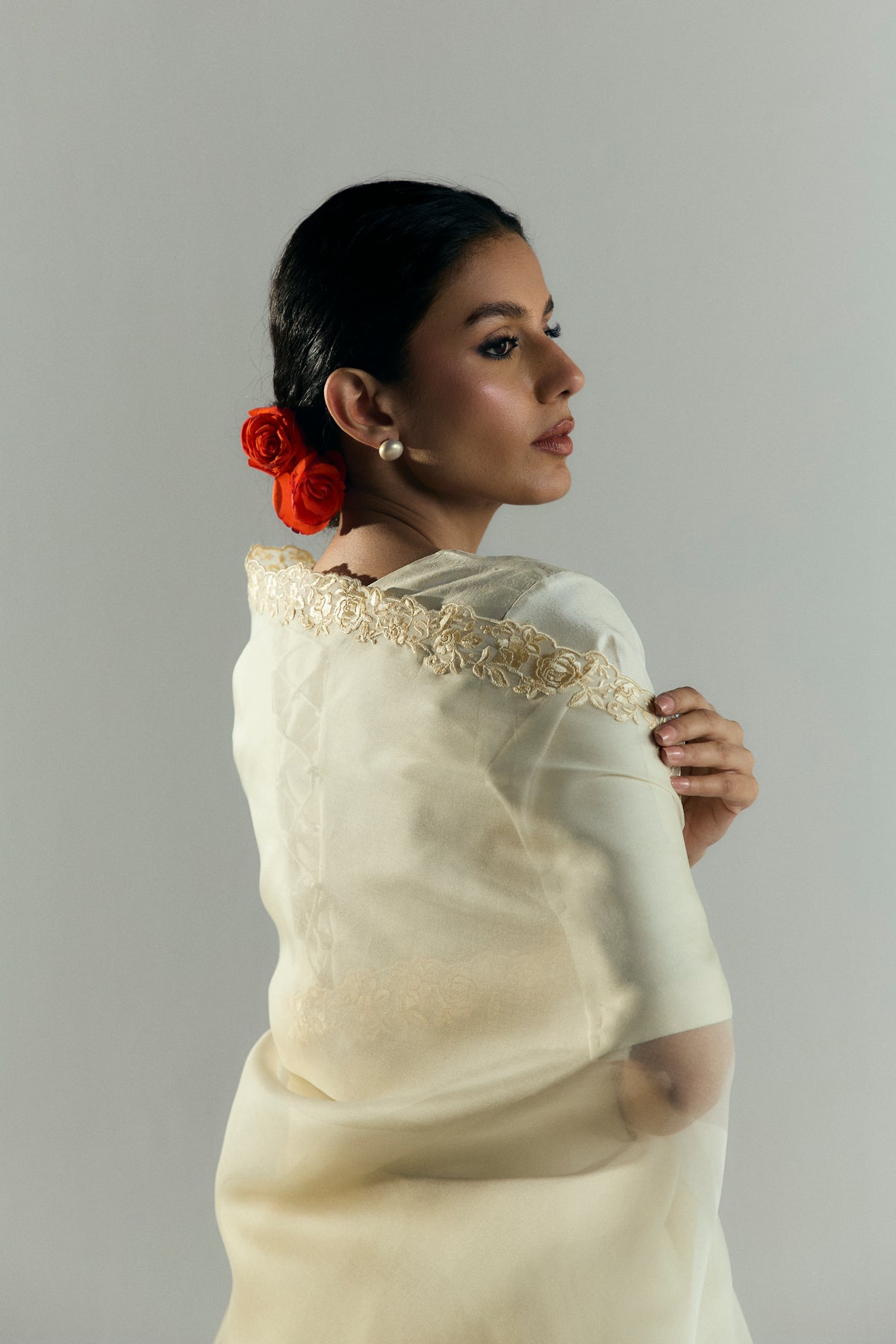 Close-up of the silk blouse's adjustable tie-back detail and the embroidered saree border on the shoulder.