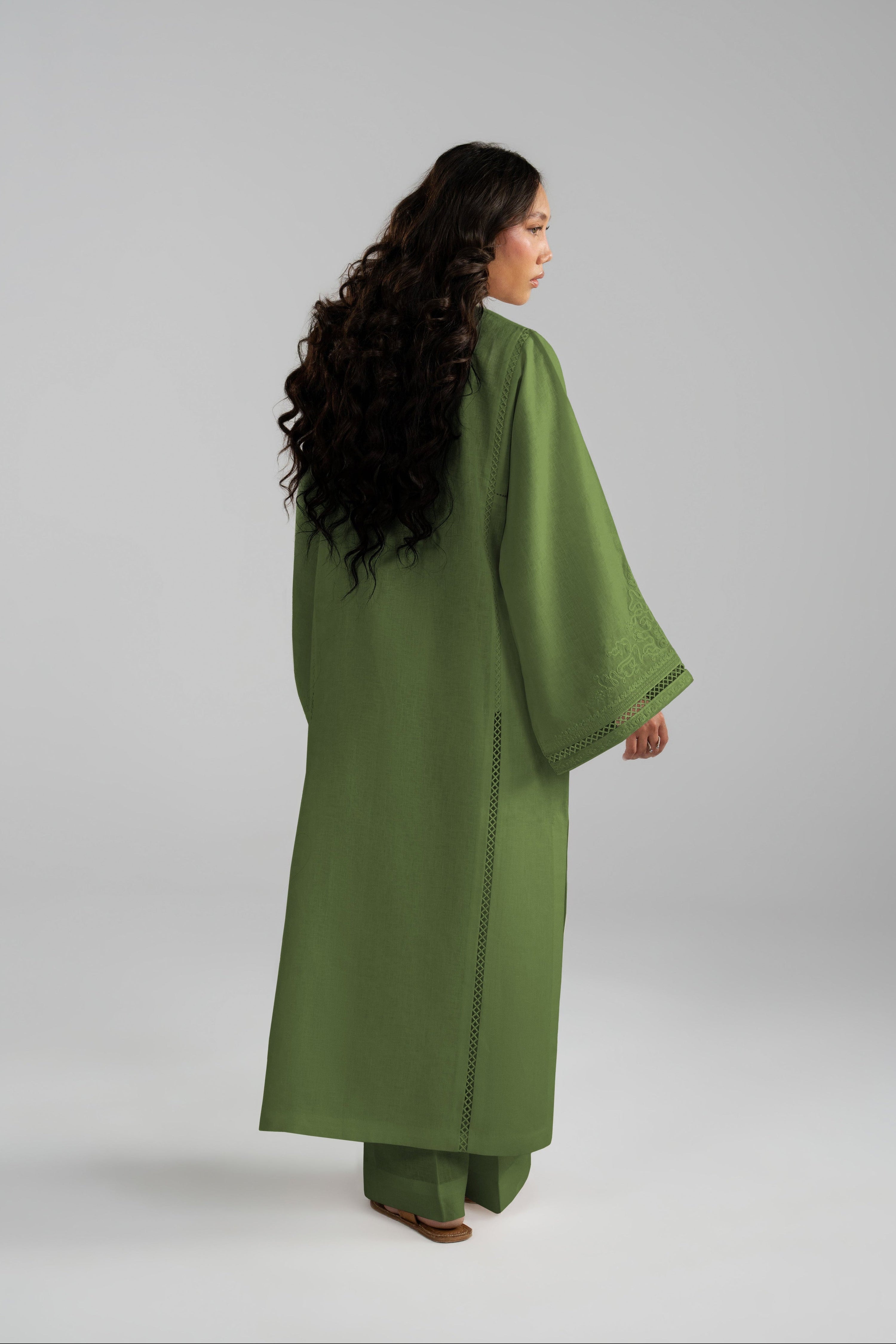 Back view of the Clover Set showing the flowing green linen tunic in motion