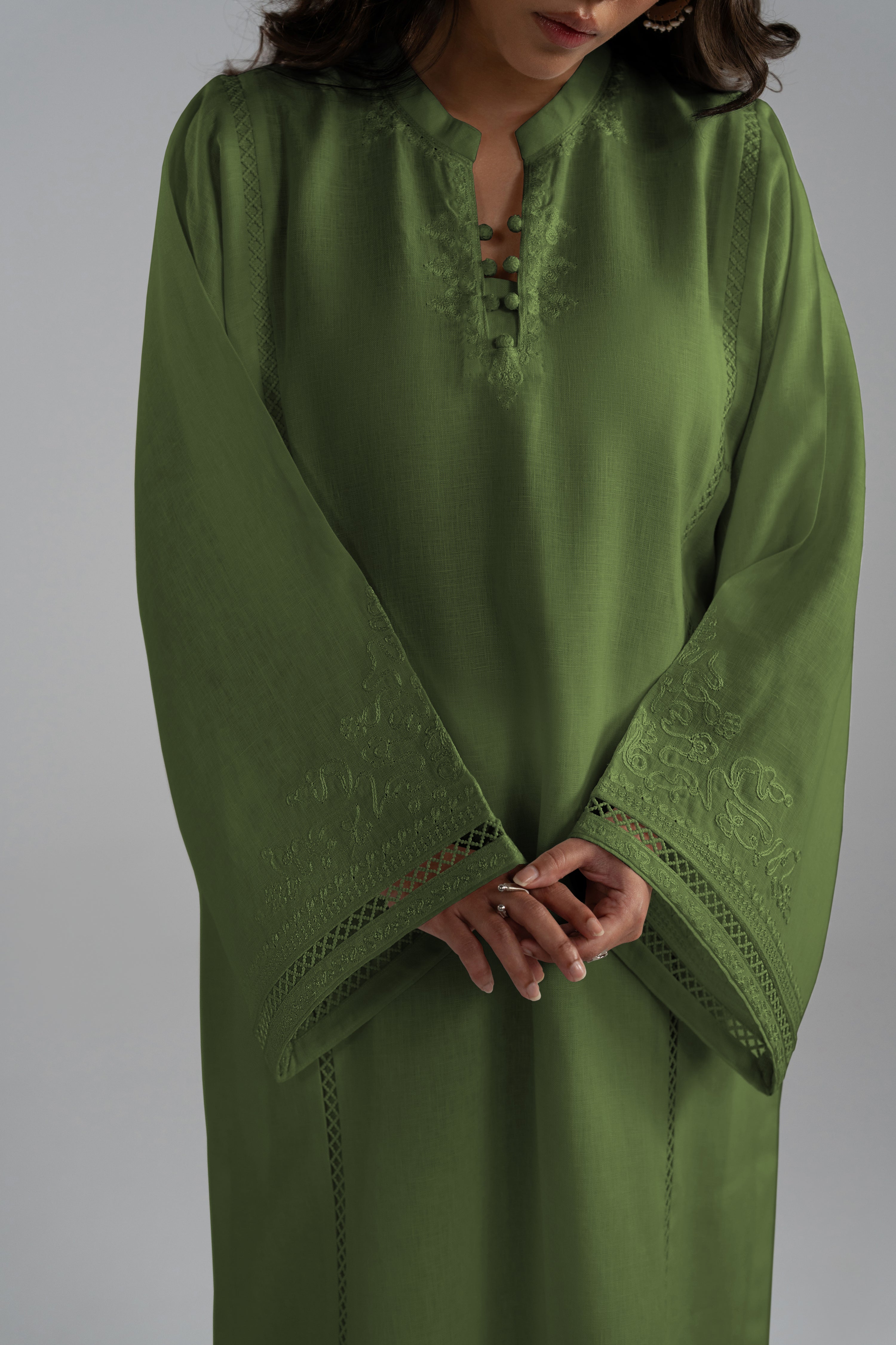 Close-up of the Clover Set's V-neckline with lace insert and aari-inspired embroidery in linen fabric