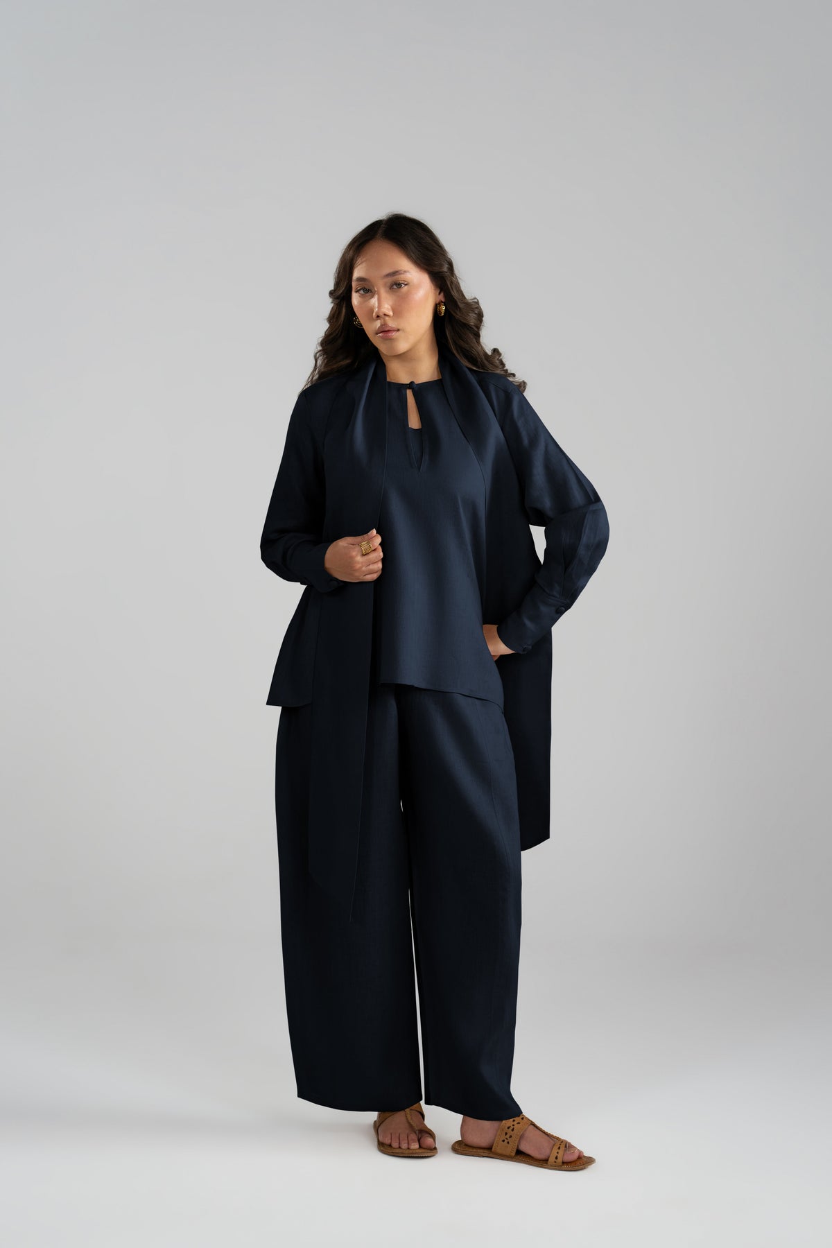 Full-length view of the Cove Set in navy blue, featuring panelled balloon trousers, short shirt and matching scarf from the linen collection.