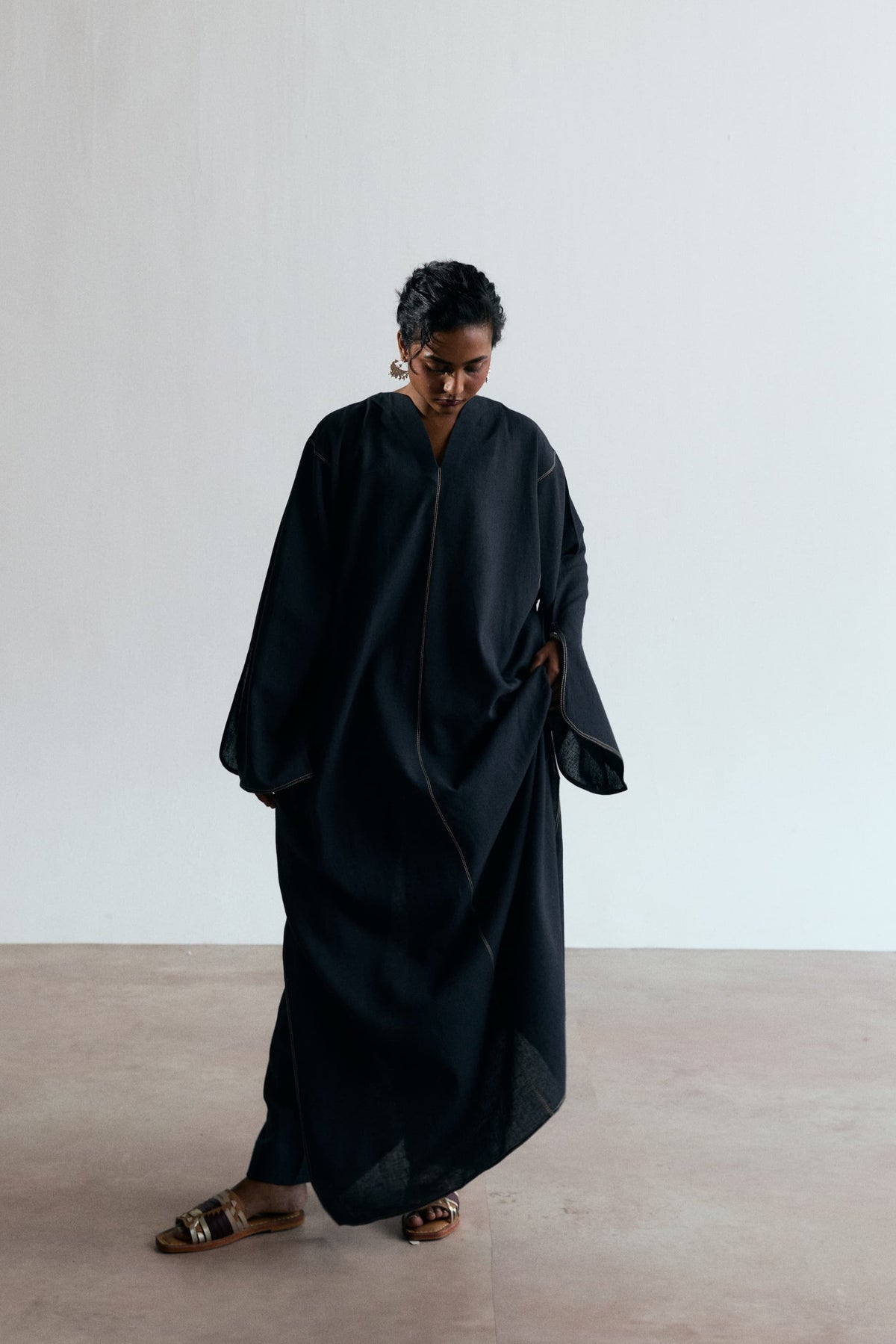 Ebony Kaftan Set with straight-leg trousers and wide sleeves, full-length view with the hem lifted