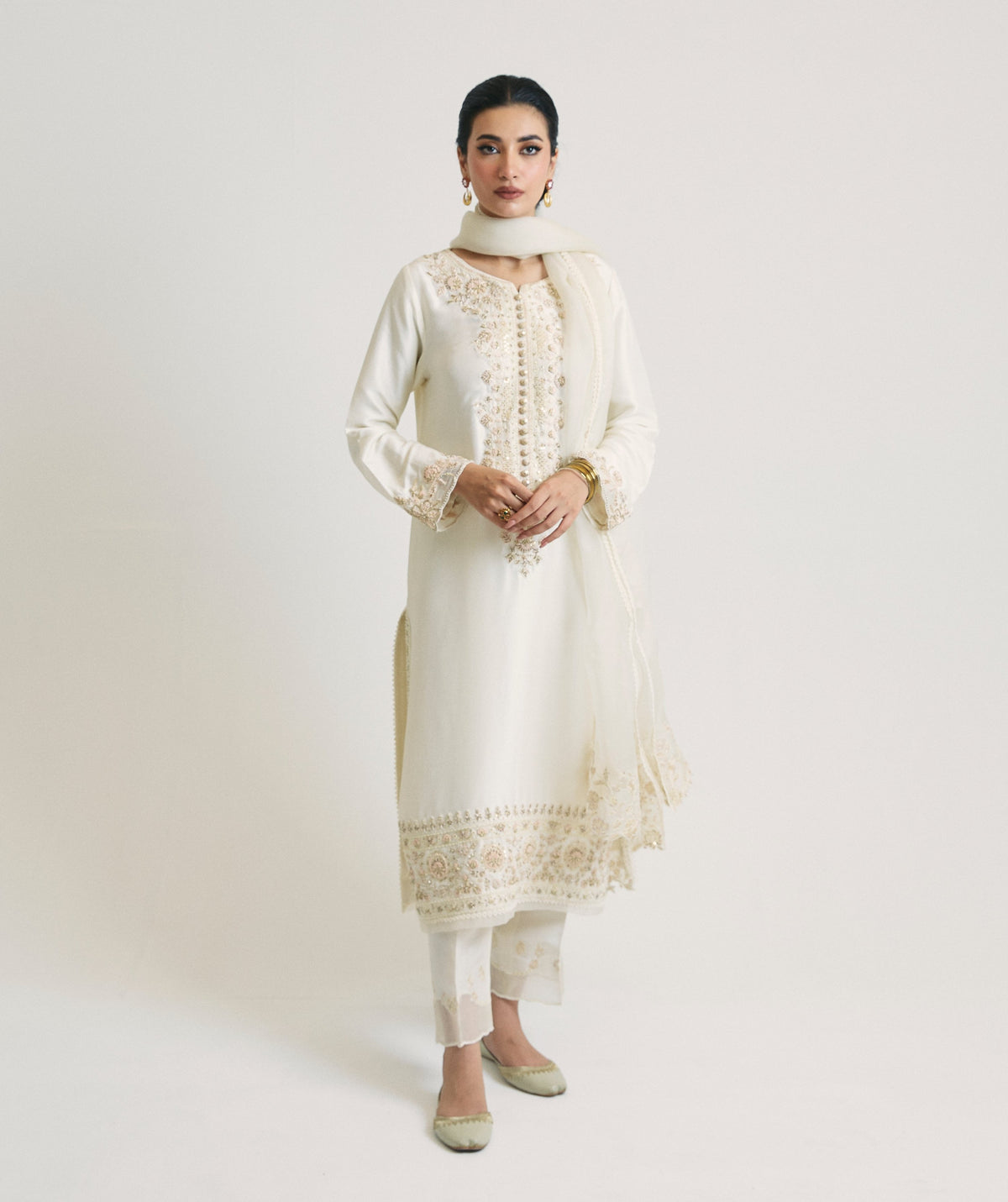 Front view of the ivory raw silk kameez featuring a hand-embroidered button placket, with an organza dupatta draped as a neck scarf.