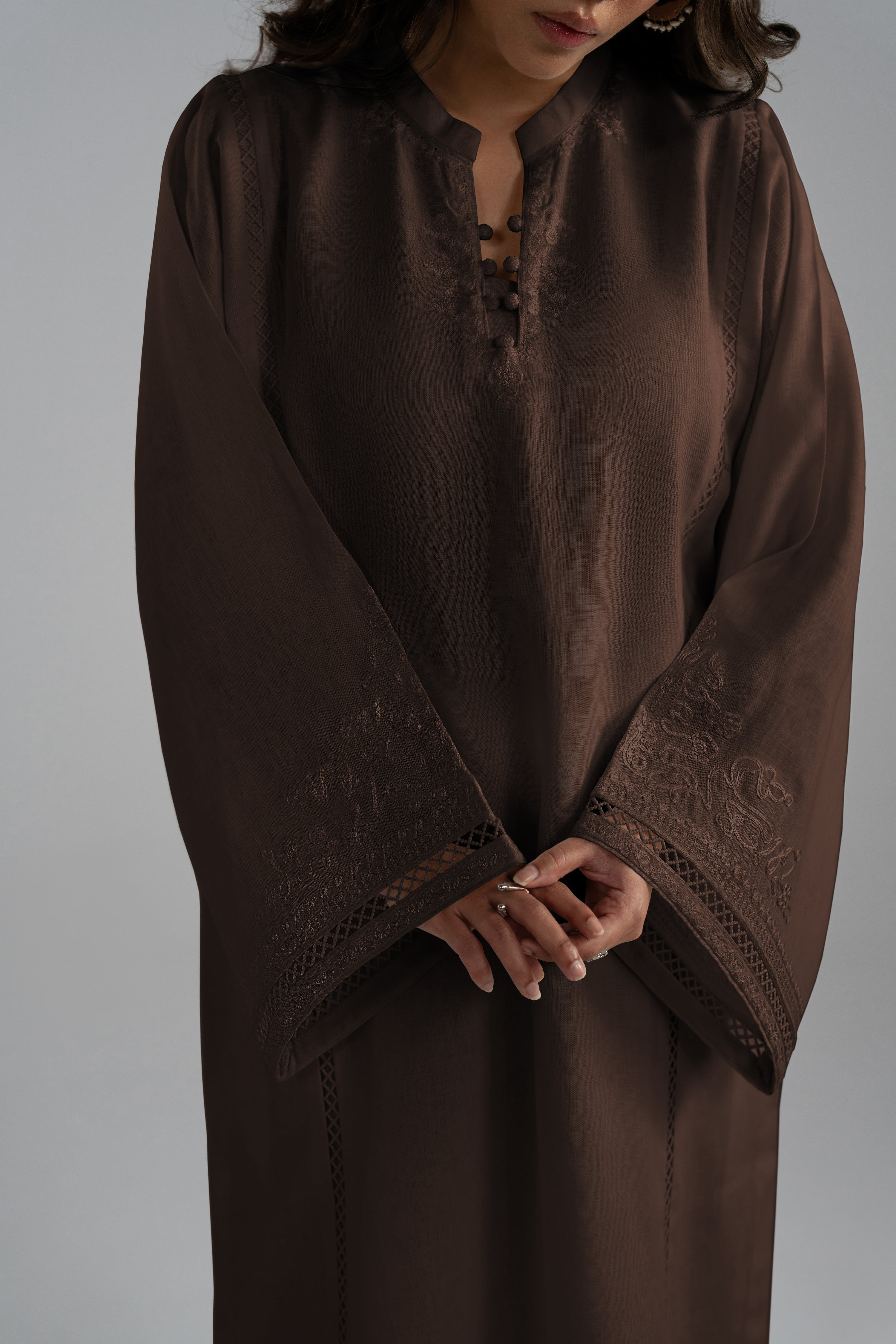 Close-up of the Maple Set in brown featuring a split V-neckline with fabric buttons, lace-insert trims, and aari-inspired embroidery on the long wide sleeves.