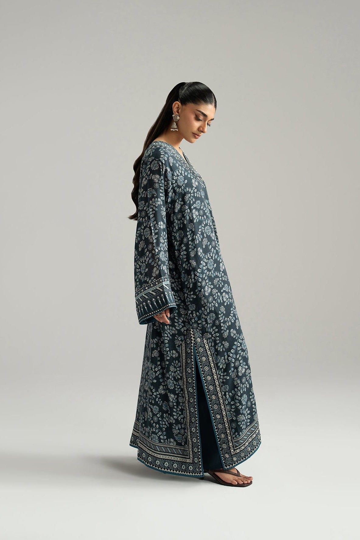 Side profile of navy blue Pakistani silk suit with printed side slit border and hem