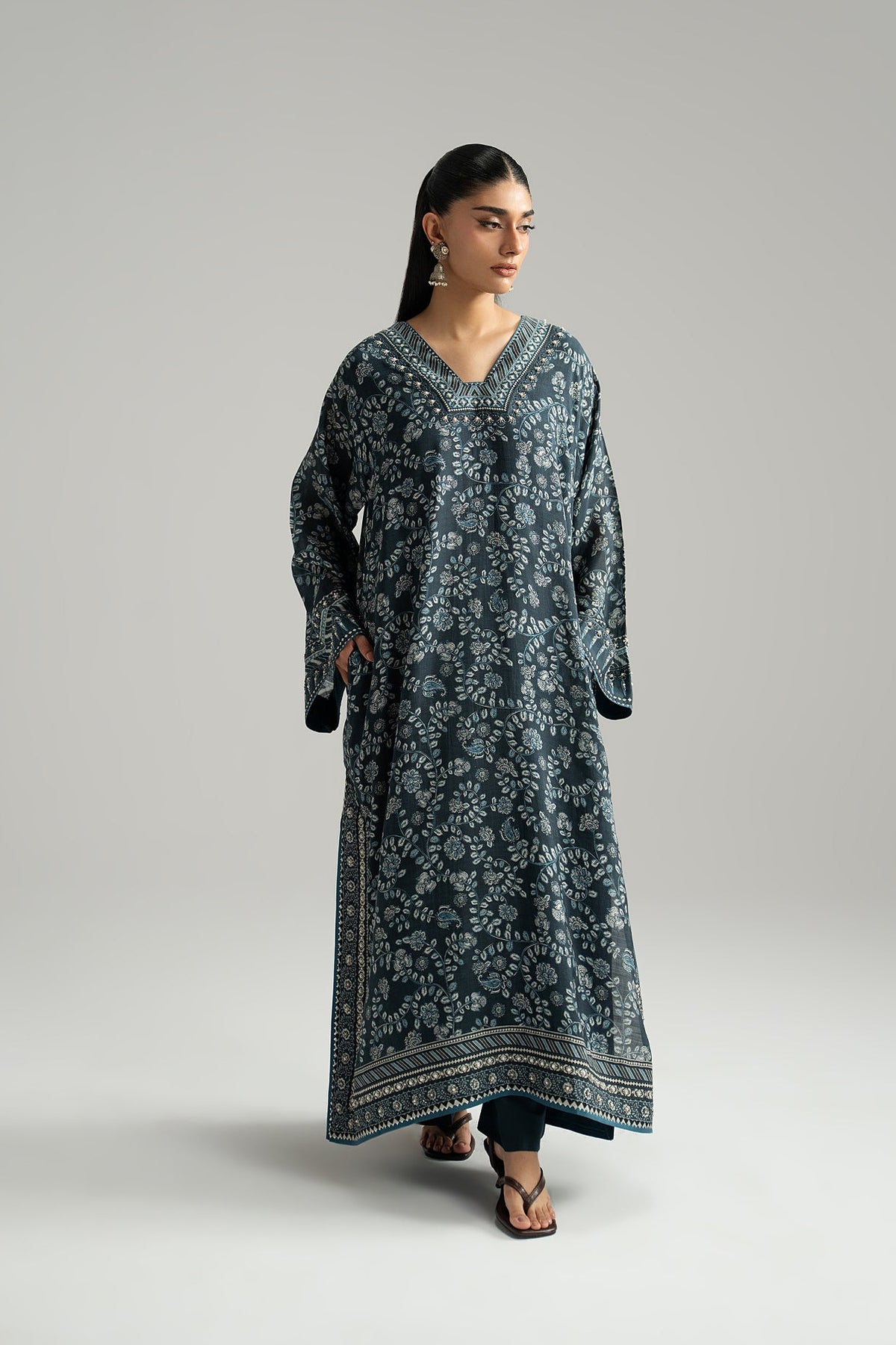 Three-quarter front view of a navy blue set with floral-print phiran, wide sleeves and printed border hem