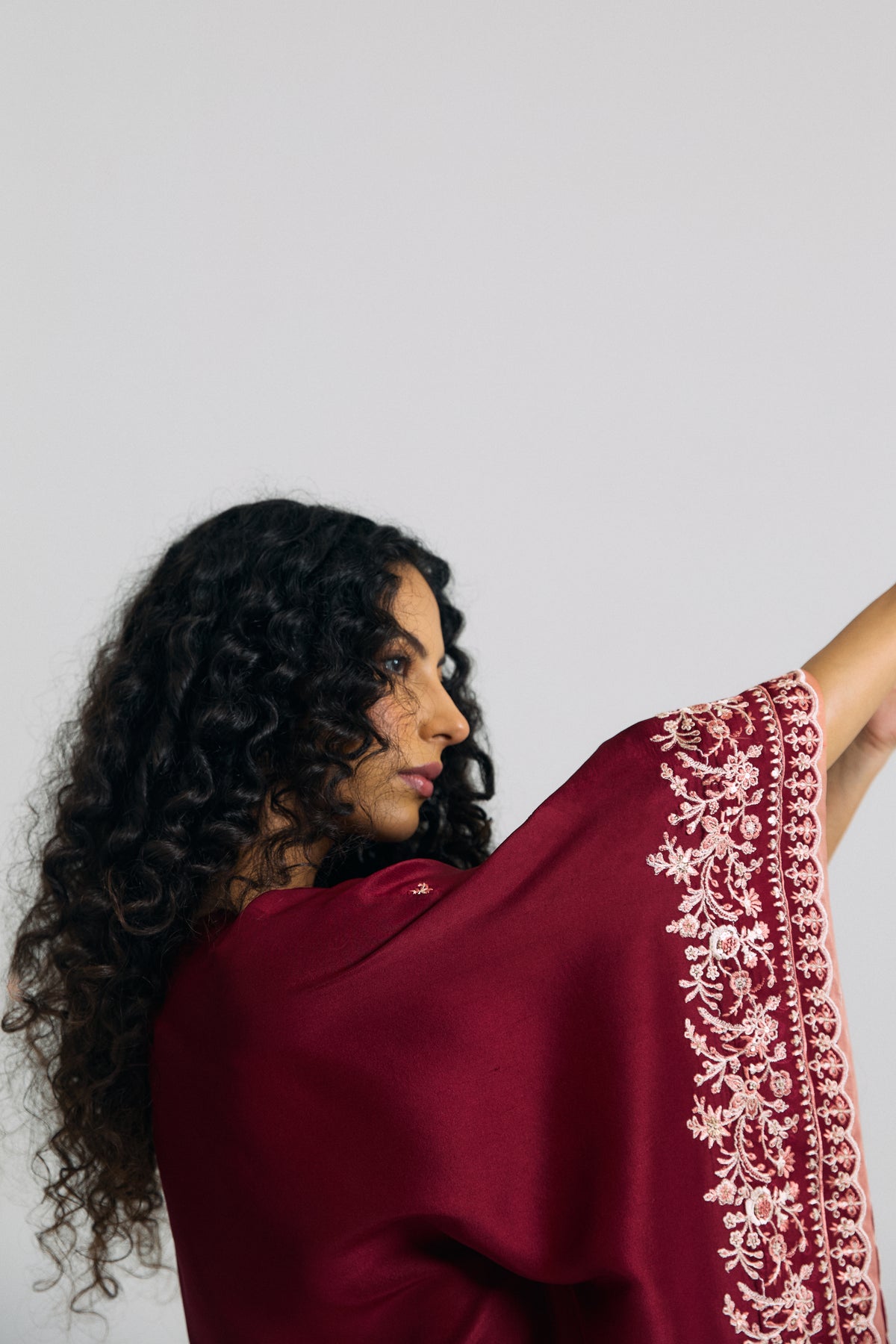 Wide sleeve border with floral adda embroidery and peach accents on a Pakistani kaftan, side view