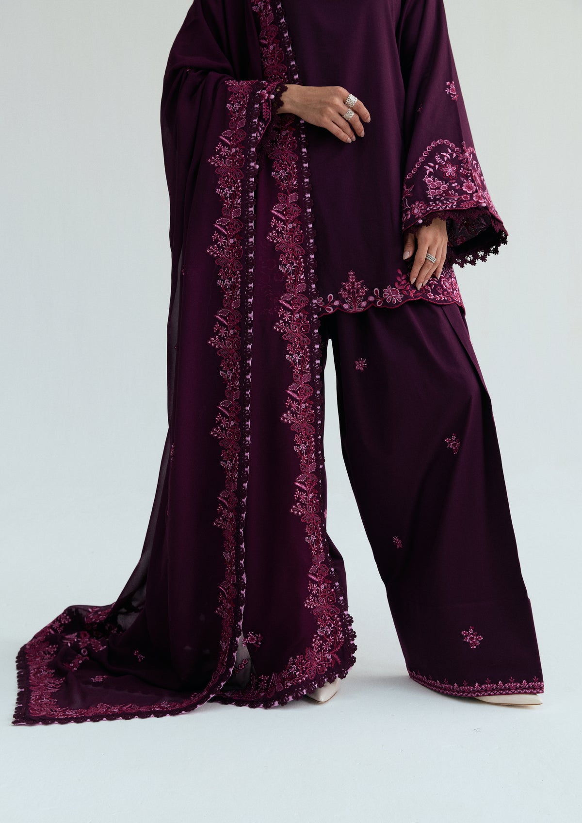 Detail of the embroidered farshi shalwar's scattered floral motifs and pink dupatta border