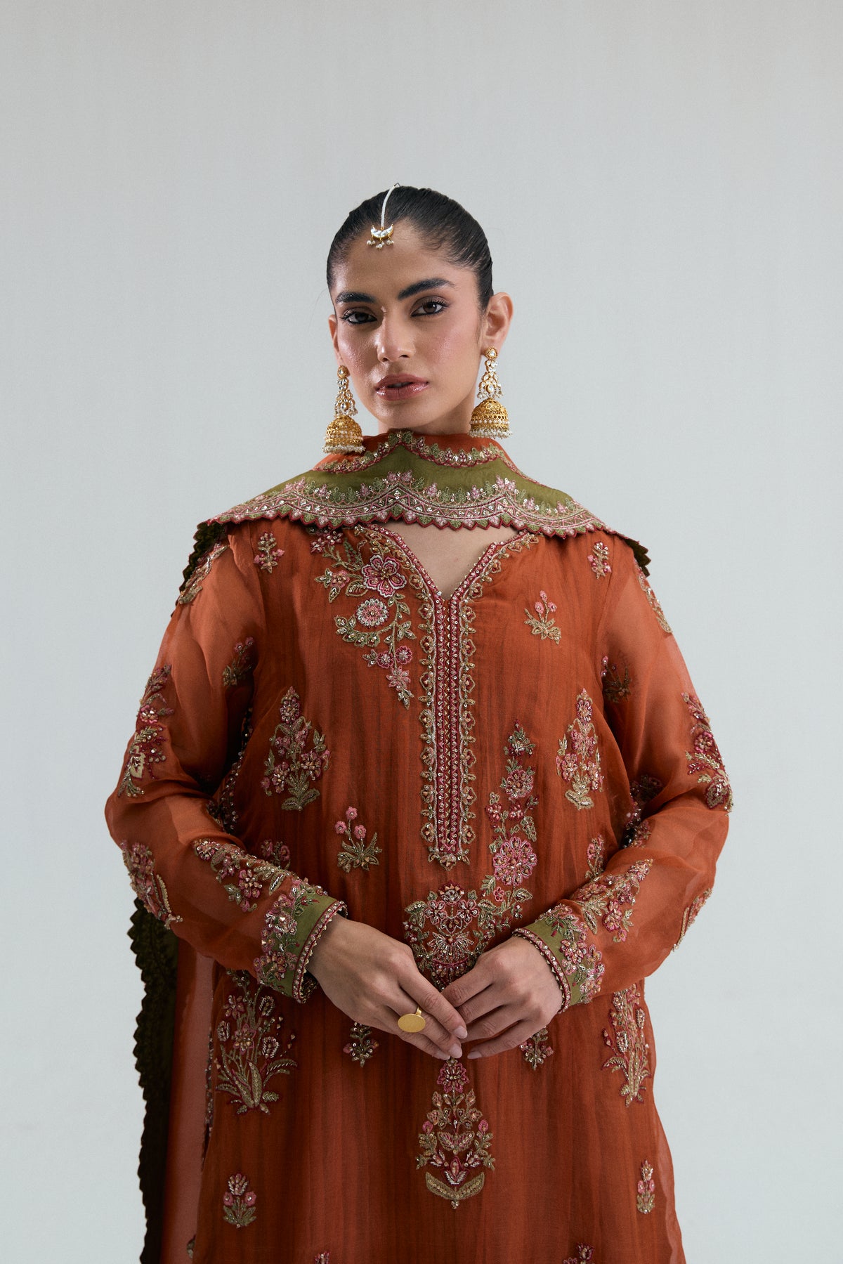 Close-up of the scalloped contrast V-neckline, showing multicoloured floral threadwork and sequin detailing