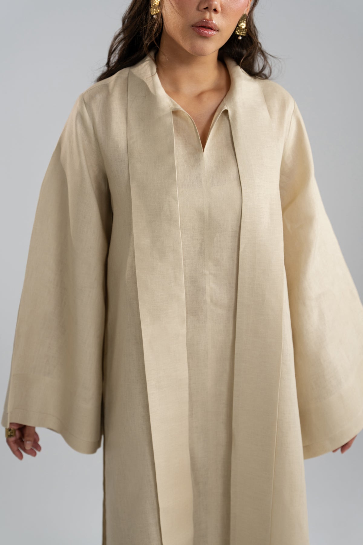 Close-up of the centre-seam pleating and scarf ties running down the front of the linen tunic